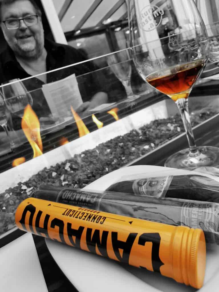 Zigarre und Rumglas vor dem Feuer