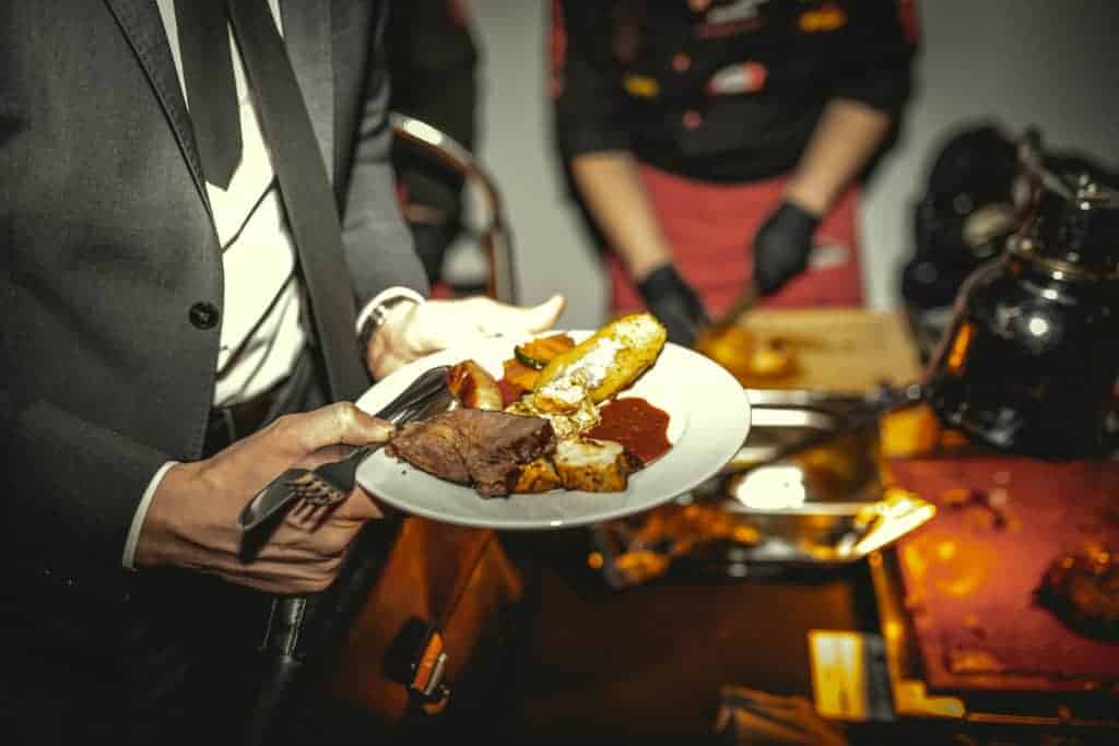Teller mit Essen in den Händen eines Teilnehmes